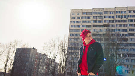 Low angle side of young male in a black leather jacket on street and looking at cameraの写真素材