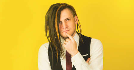 Pensive business man taps his chin with finger.