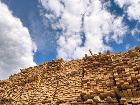 Wooden boards, lumber, industrial wood, timber. Pine wood timber stack of natural rough wooden boards on building site. Industrial timber building materials.の写真素材