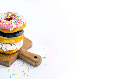 Delicious donuts on wooden board, placed on wooden cutting board on white background.の写真素材