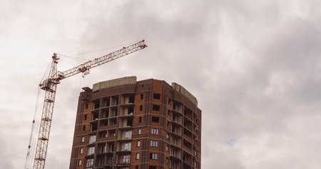 High crane against cloudy sky. The low angle of inclination of a modern high crane and a...