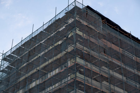 Facade restoration of building against sky. Reconstruction of building exterior with scaffolding