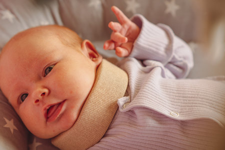 Cute newborn baby in a neck brace. Kid wearing cervical collar, Treatment of spinal injury in a child.の写真素材