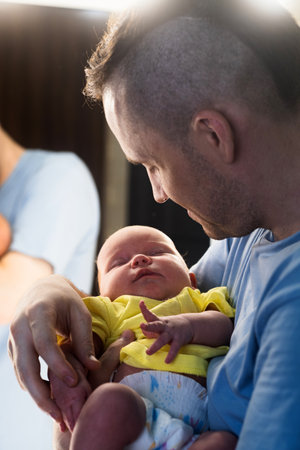Dad holding a newborn baby in his at homeの写真素材