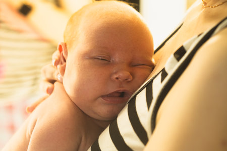 Newborn baby sleeping in mother's arms. close-up.の写真素材