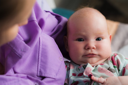 Portrait of a newborn baby girl in her mother's arms.の写真素材