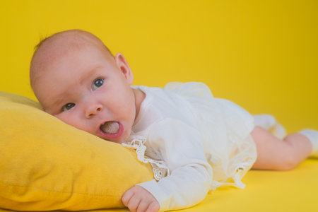 Portrait of a cute baby on a yellow background with copy spaceの写真素材