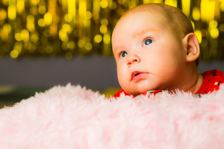 Newborn baby girl with blue eyes on the background of Christmas lightsのeditorial素材