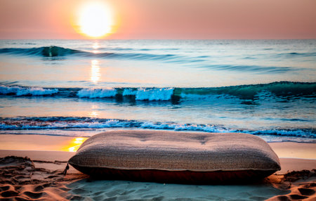 pillow on the sand by the sea at sunset.の素材