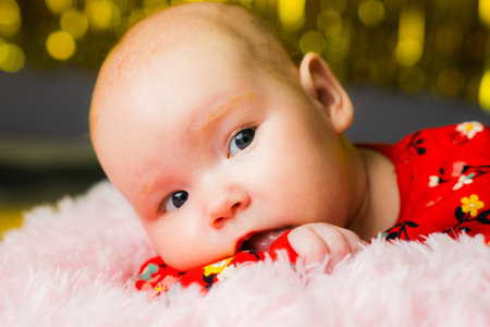 Newborn baby girl lying on pink fur with bokeh background