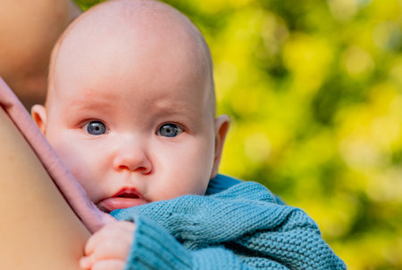 Close-up portrait of a newborn baby in the arms of his motherの写真素材