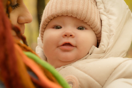 baby in the arms of his mother in the autumn park. soft focus