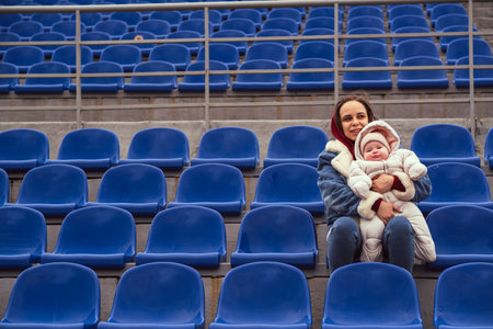 A young mother and her newborn daughter at the stadiumの写真素材