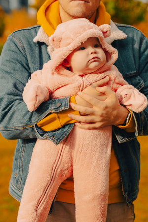 Cute baby girl with her father in autumn park. Happy family.