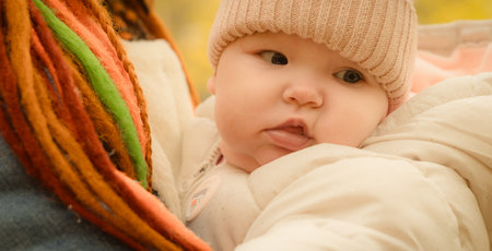 baby in the arms of his mother in the autumn park. soft focusの写真素材