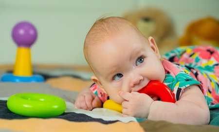 Portrait of a cute baby girl playing with colorful toys at home.の写真素材