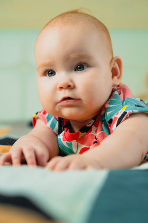 Portrait of a cute baby girl with blue eyes in colorful dress.の写真素材