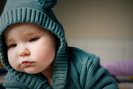 Portrait of a cute little baby girl in a knitted hat and warm clothes.の写真素材