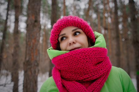 Woman Wearing Pink Scarf and Green Jacket. A woman confidently wears a pink scarf and a green jacket, creating a stylish and vibrant look.の写真素材