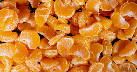 Peeled tangerines on a black background. Slices of tangerine or mandarin fruit close upの写真素材