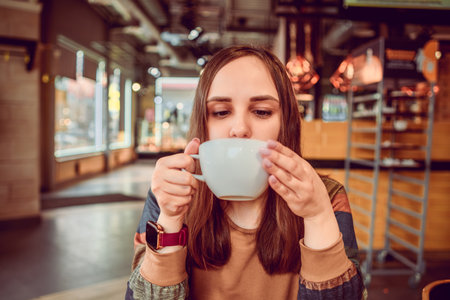 Serene Morning Moment as a Young Woman Sips Coffee in a Cozy Urban coffee shop.