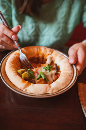 A savory dish of veal and roast vegetables in tomato sauce, presented in an artisanal edible bread...
