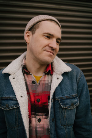 Man Wearing Hat and Jacket. A man standing outdoors wearing a hat and jacket