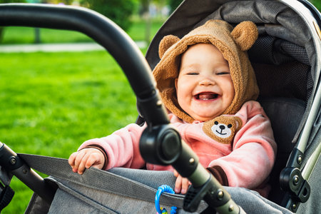 Portrait of a cute toddler girl in a stroller in the park.