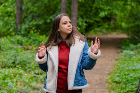 A woman is energetically dancing in the forest. She exudes confidence and joy as she moves gracefully.の写真素材