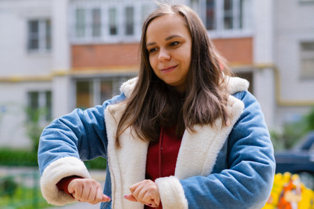 A woman is energetically dancing in front of a building. She exudes confidence and joy as she moves gracefully.の写真素材