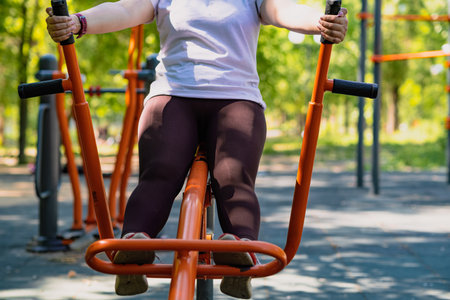 Woman Working Out on Outdoor Exercise Equipment in the Park.