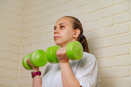 Woman Lifting Green Dumbbells During Home Workout