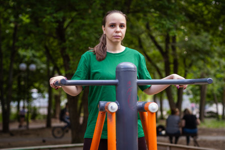 Woman Working Out on Outdoor Exercise Equipment in the Park.