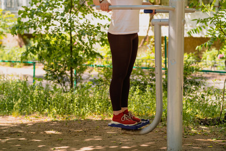 Woman Working Out on Outdoor Exercise Equipment in the Park.