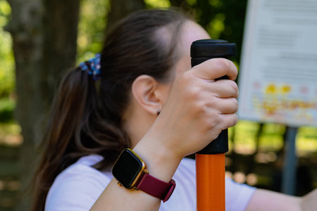 Woman Working Out on Outdoor Exercise Equipment in the Park.の写真素材
