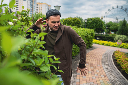 Handsome Man Dancing Enthusiastically in a Lush Green Park on a Cloudy Afternoon.