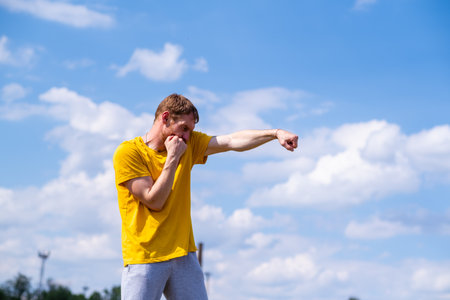 Man Practicing Boxing Moves in Scenic Park on a Sunny Afternoon.