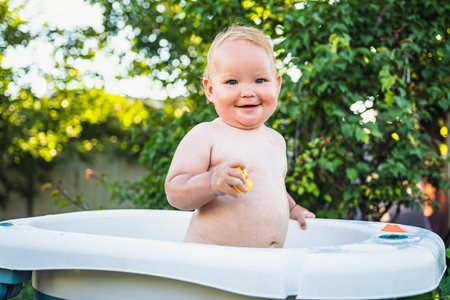 A Baby's Delightful Bubble Bath Adventure in the Summer Sun.の写真素材