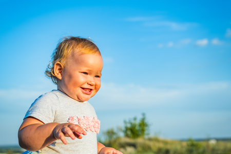 Adventurous Baby Strolling Through a Field at Sunset in the Evening Glow.の写真素材