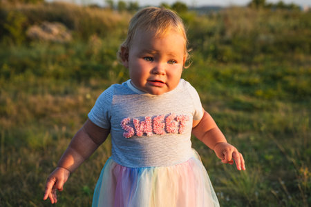 Happy Baby Enjoying Sunshine While Playing Outdoors in a Green Field.の写真素材