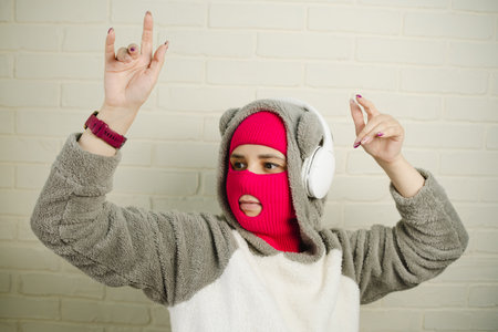 Woman in pink Balaclava Dancing Against a White Brick Wall