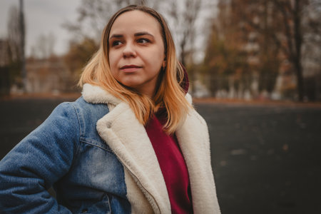 A young woman explores an urban park during an overcast day, surrounded by towering buildings and...