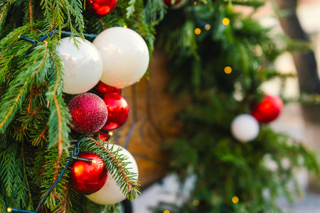 Bright Holiday Decorations Featuring Red and White Ornaments on Evergreen Branches in a Festive Setting.の写真素材