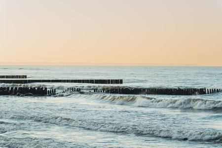 Stunning View of Sea Breakwater With Gentle Waves and Pastel Sky During Evening Hours.の写真素材