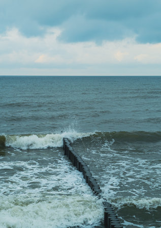 Breakwater at Dusk Surrounded by Calm Waves and a Distant Horizon.