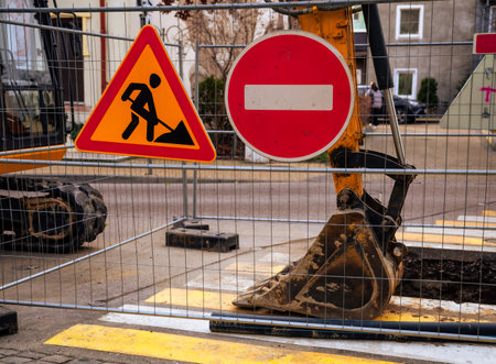 Construction Work in Progress With Warning Signs and Equipment on City Street During Daytime.の写真素材