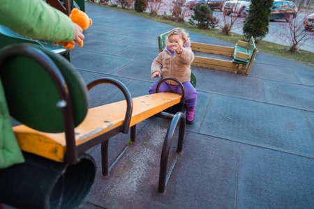 Young Child Enjoys Playtime on a Seesaw in a Park During a Sunny Day.の写真素材