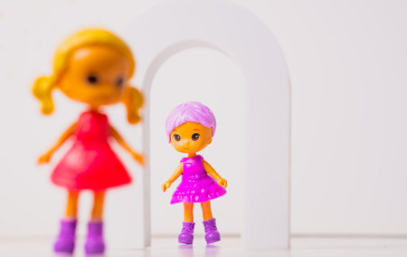 Toy dolls playing together in a vibrant setting with an arch.の写真素材