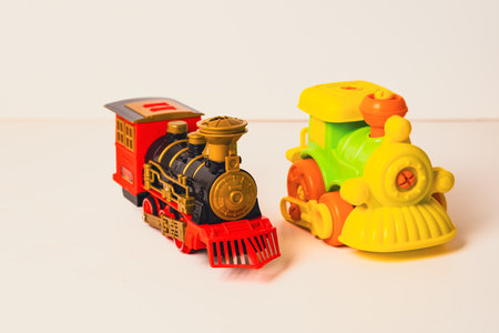 Brightly colored toy trains standing together on a white surface, ready for imaginative playtime adventures.の写真素材