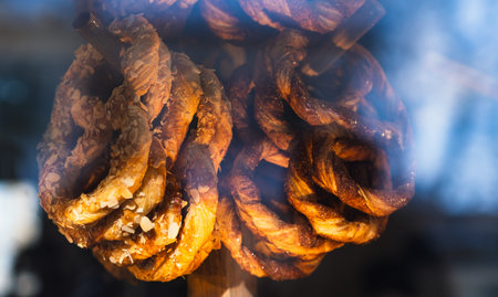 Delicious almond pretzel twists in a bakery display. Sweet pastry baked golden brown. Freshly baked dessert for snack or breakfastの写真素材